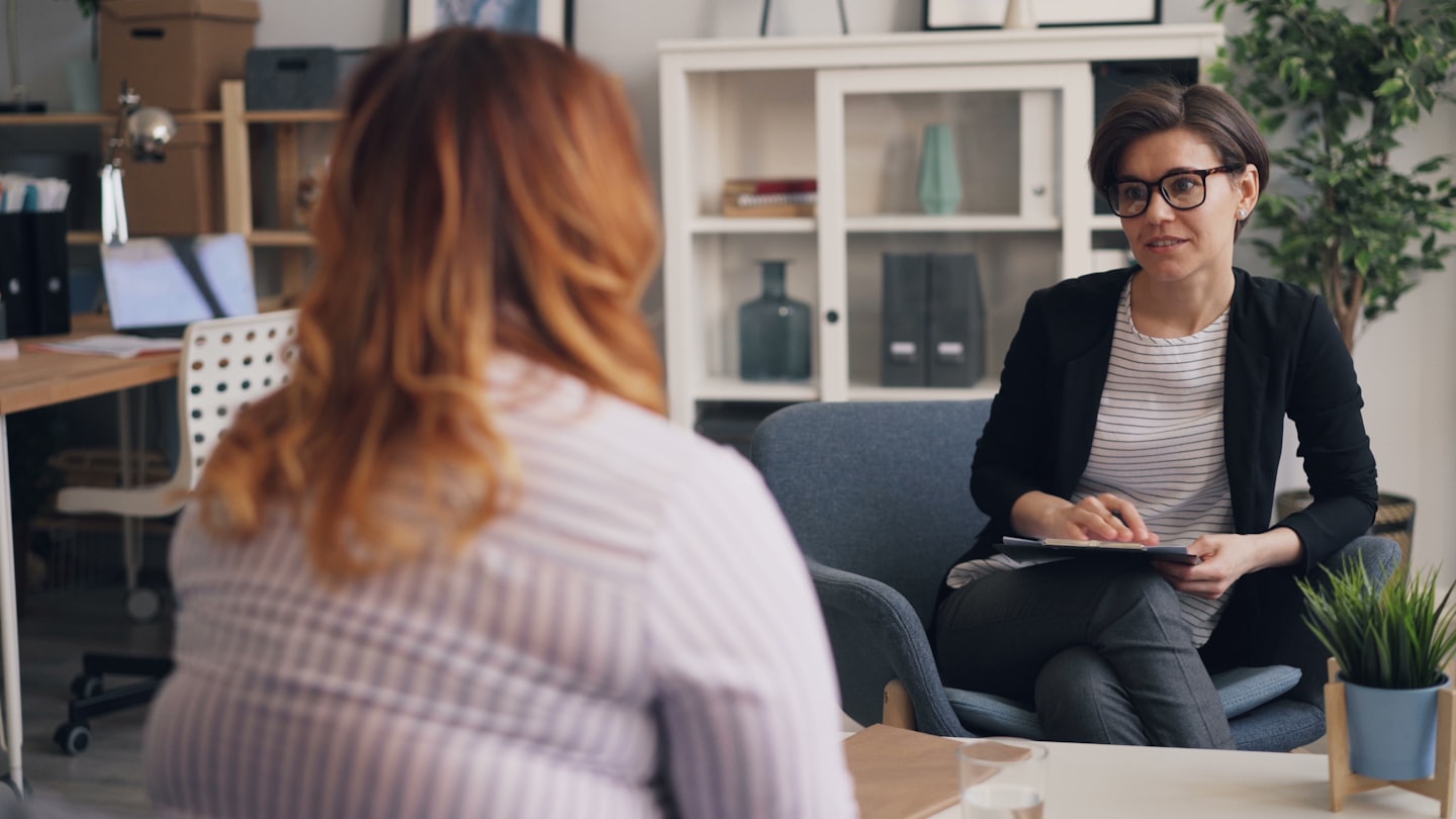 Due donne in una sessione di consulenza professionale in un ufficio luminoso.